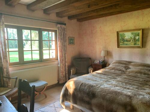 une chambre avec un grand lit et une fenêtre dans l'établissement ENOLAND La maison du bonheur, à Bourdonné