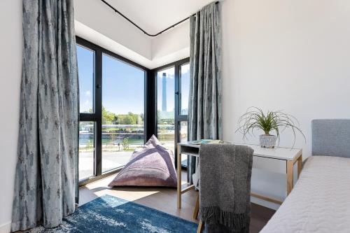 Habitación con escritorio y ventana. en Sea View Family Apt in Unique Kalaranna District en Tallin