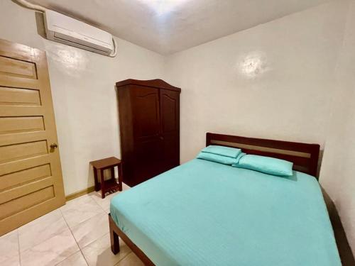 1 dormitorio con 1 cama con sábanas azules y vestidor en M & M 's Home Stay en Puerto Princesa