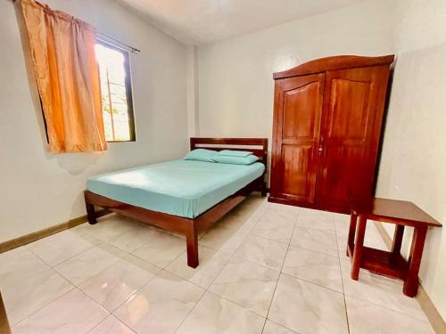 1 dormitorio con 1 cama, armario y ventana en M & M 's Home Stay en Puerto Princesa