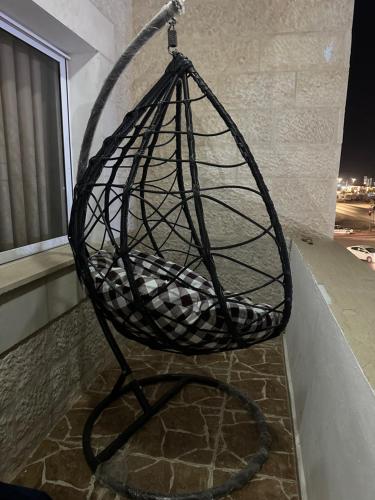 a black basket chair on a balcony at night at Furnished Two bedroom apartment in Irbid in petra st in Irbid