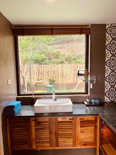 a bathroom with a sink and a window at Anna Little Garden - Fish House in Sóc Sơn
