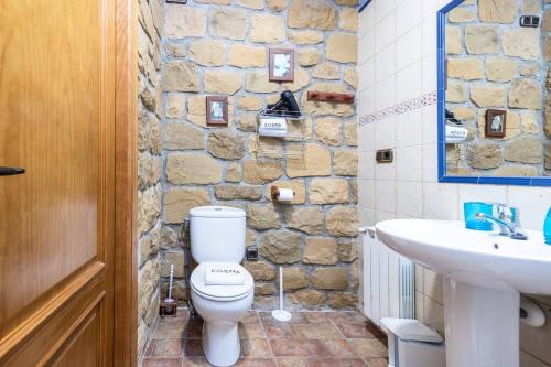 uma casa de banho com um WC branco e um lavatório. em PERRATZU LANDARBIDE-Ideal parejas em Aia