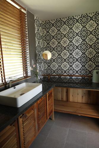 a bathroom with a sink and a black and white wall at Anna Little Garden - Fish House in Sóc Sơn