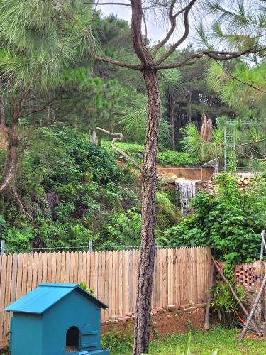 a blue dog house sitting next to a fence at Anna Little Garden - Fish House in Sóc Sơn