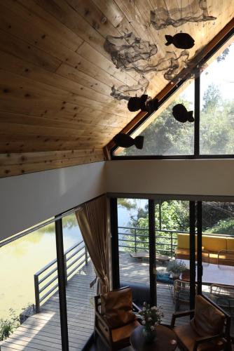a room with large windows and a wooden ceiling at Anna Little Garden - Fish House in Sóc Sơn