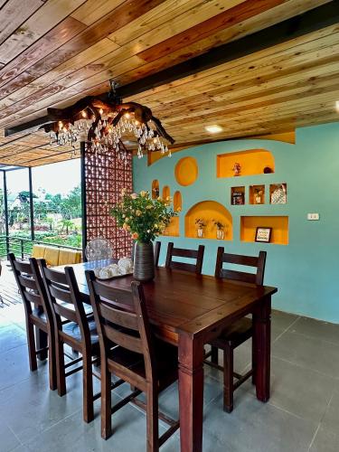 a dining room with a wooden table and chairs at Anna Little Garden - Fish House in Sóc Sơn