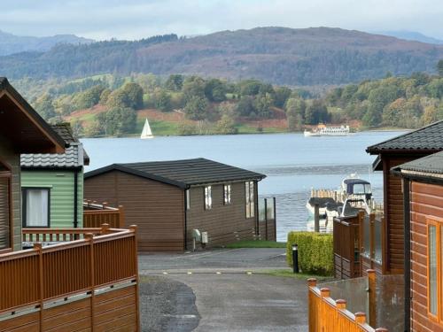 a view of a lake with houses and a boat at V+B Hygge in Windermere