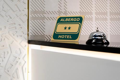 a sign for a albergo hotel sitting on a shelf at London Hotel in Milan