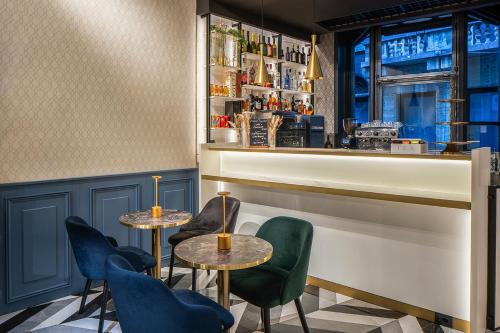 a restaurant with two tables and chairs and a bar at London Hotel in Milan