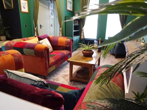 a living room with colorful couches and a table at Havana House - Luxury Property Near Harbour in Weymouth