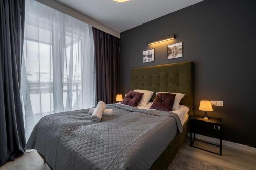 a bedroom with a bed with a large window at RentPlanet - Apartamenty Zakopiańskie in Zakopane