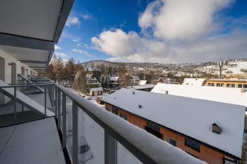 a balcony with snow on the roofs of buildings at RentPlanet - Apartamenty Zakopiańskie in Zakopane