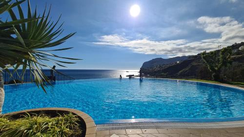 a large blue swimming pool next to the ocean at Ocean view and Infinity pool Apartment in Funchal