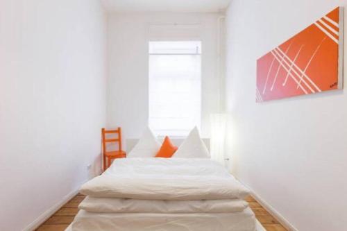 a white room with a bed and a window at Stylish & Tranquil in Berlin