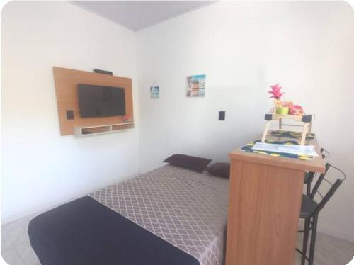 1 dormitorio con 1 cama y escritorio con TV en Apartamento Superior, en Balneário Camboriú