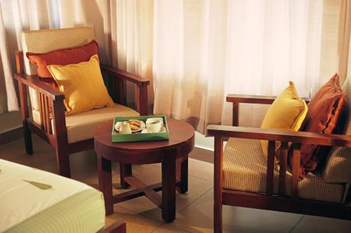 um quarto com uma cadeira e um prato de comida numa mesa em Dutch Manor Boutique Hotel em Cochin