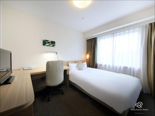 Un pat sau paturi într-o cameră la Daiwa Roynet Hotel Kyoto-Hachijoguchi