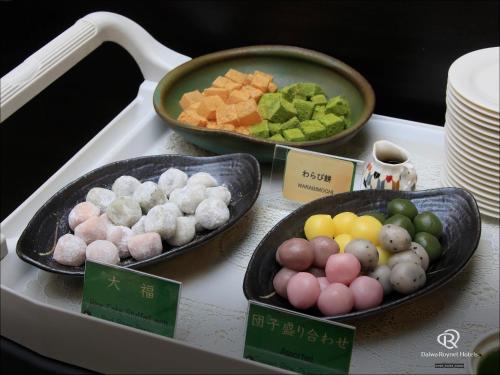 a table with three plates of food on a stove at Daiwa Roynet Hotel Kyoto-Hachijoguchi in Kyoto