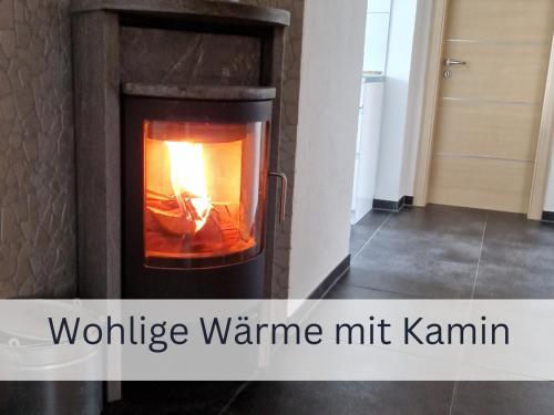 a wood burning stove in a room with the words wildfire warmmite hit kami at Bergliebe - Gipfelstation in Blaichach