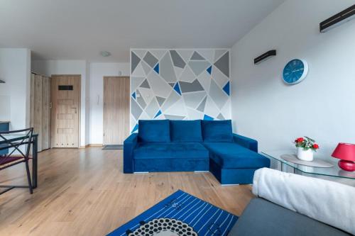a living room with a blue couch and a table at Apartament Lazurowy widok - z prywatnym parkingiem - SpaceApart in Karpacz