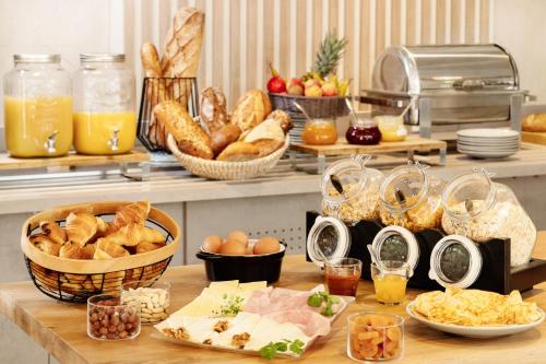 - un buffet avec du pain et d'autres aliments sur une table dans l'établissement Hôtel Valdys Thalasso & Spa - les Pins, à Saint-Jean-de-Monts