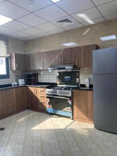 a kitchen with a stove and a refrigerator at The Ocean Villa in Fujairah