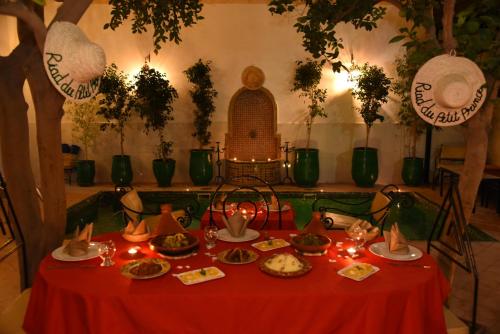 a red table with food and candles on it at Riad Du Petit Prince in Marrakech