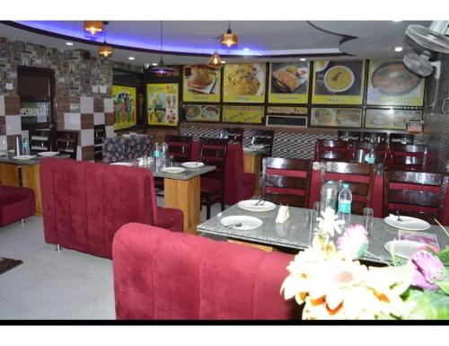 un restaurant avec des tables et des chaises rouges dans l'établissement Hotel Om Karan Katra, à Katra