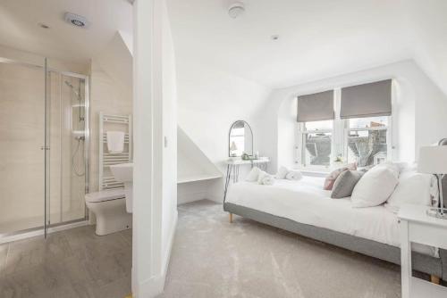 een witte slaapkamer met een bed en een badkamer bij Skye Sands - Balgove Penthouse Residence - St Andrews in St Andrews