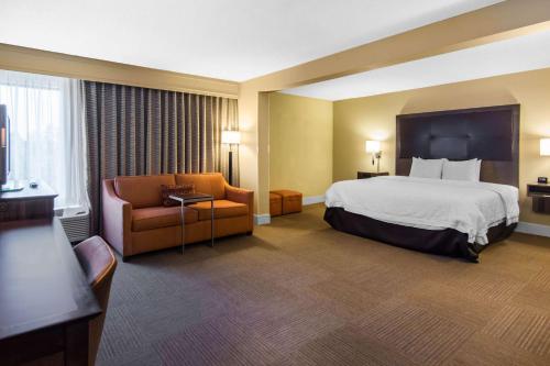 a hotel room with a bed and a chair at Wingate by Wyndham Steubenville in Steubenville