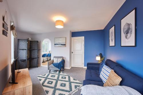 sala de estar con paredes azules y sofá azul en Seaside Retreat sleeping 4 en Ilfracombe