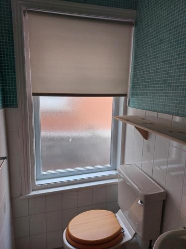 een badkamer met een toilet en een raam bij Witton house in Blackpool