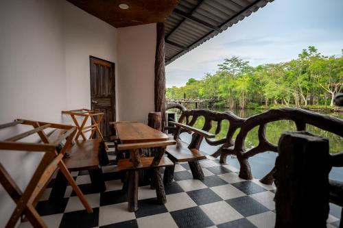 a room with a table and chairs and a view of a river at Tamnanpar Resort in Ban Phe