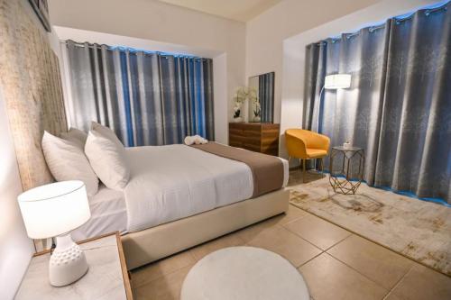 1 dormitorio con 1 cama blanca y 1 silla amarilla en 54 Floor Palm & Sea View Dubai Marina. LUX / NEW, en Dubái