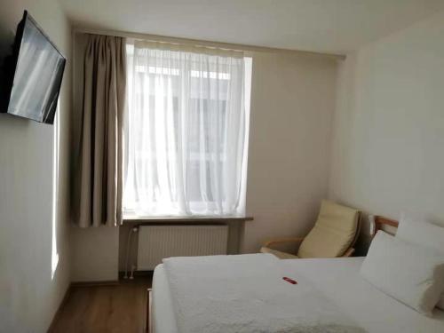 a hotel room with a bed and a window at Hotel Hanseatic-garni in Wuppertal