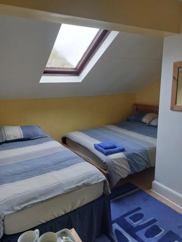twee bedden in een kamer met een dakraam bij Witton house in Blackpool