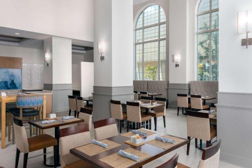 a restaurant with tables and chairs and windows at Hilton Garden Inn Charlotte Uptown in Charlotte