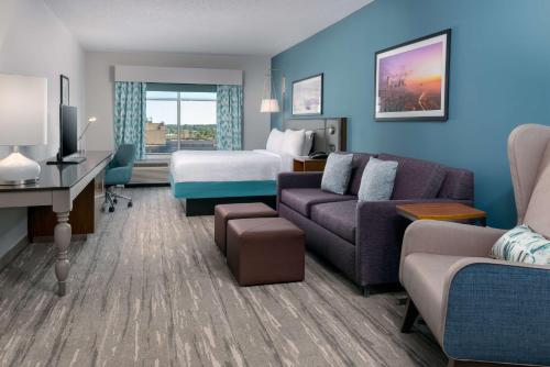 um quarto de hotel com uma cama e uma sala de estar em Hilton Garden Inn Charlotte Uptown em Charlotte