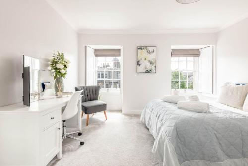 a white bedroom with a bed and a desk at Skye Sands - South Street Residence - St Andrews in St. Andrews