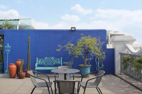 a patio with a table and chairs and a blue wall at Noor Hotel in Bandung
