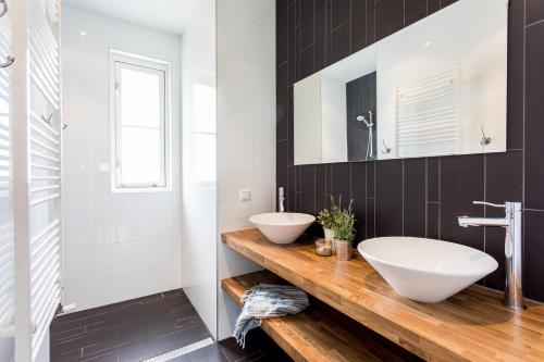 a bathroom with two sinks and a mirror at De Gouden Spar in Noordwijk