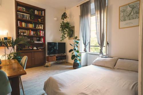 a bedroom with a bed and a desk and a tv at Vaticano/Trastevere Floreal Suite in Rome