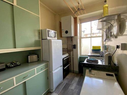 eine Küche mit einem weißen Kühlschrank und einem Fenster in der Unterkunft Abbotsford Place - Sleeps 6 - Parking in St Andrews