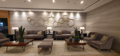 una sala de estar con sofás, mesas y lámparas. en C Place - Capsule A en Manila