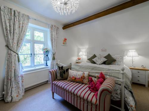 een slaapkamer met een bed, een bank en een kroonluchter bij 2 Bed in Grange Over Sands 78871 in Grange Over Sands