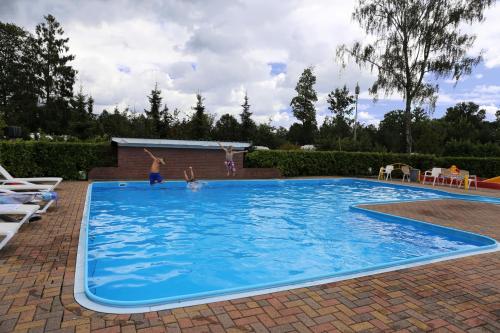 dos niños jugando en una gran piscina azul en Camping de Meibeek en Ruurlo