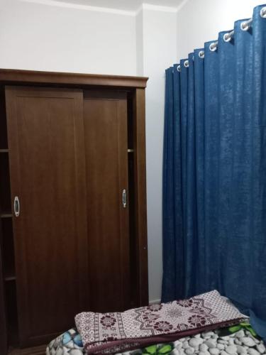 a bedroom with a bed and a blue curtain at Ikea flat 7 in Hurghada