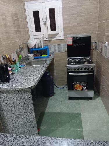 una cucina con piano cottura e lavandino di Ikea flat 7 a Hurghada