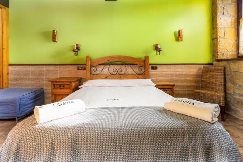 a large bed in a room with green walls at BARRUTI LANDARBIDE - Para desconectar en plena naturaleza in Aia